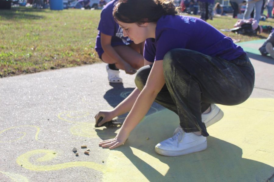 Sophomore Tessa Harrison begins to run out of yellow chalk while drawing the sun.
