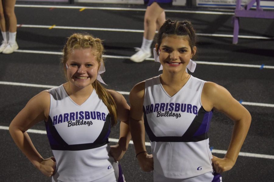 Junior cheerleaders Andra Murphy and Allexa Walker pose for photo on the sidelines. 