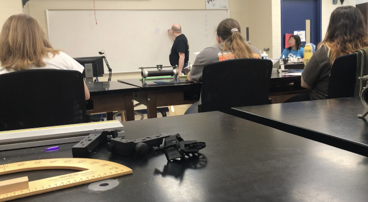 An SIC instructor teaches atomic structure to students. 