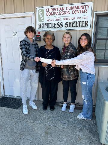 Key Club members senior Sebastion Brown, (club president) Sofie Brombaugh, and junior Bella Capuzzo donate to the 4Cs.