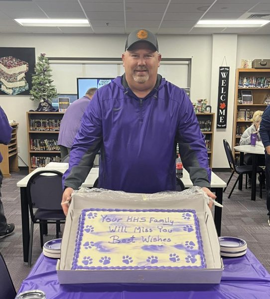 Former principal Scott Dewar poses for a photo with a cake for him. HHS staff held a goodbye party for him Nov 21. 