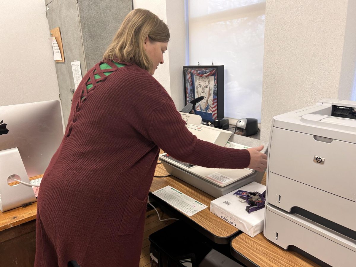 History teacher Marj DeNeal grades the post test for U.S History Honors using the scantron machine. 