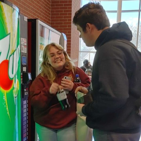 HHS students Bailey Cook (Senior) and Zech Underwood (Junior) chat beside the vending machines outside of the cafeteria. 