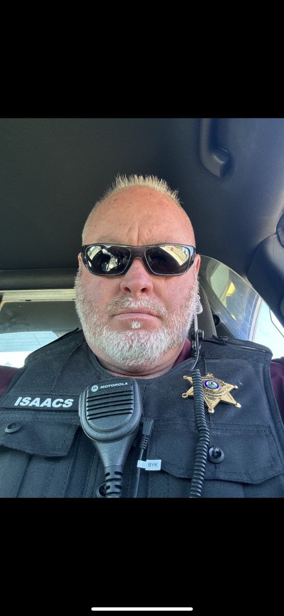 Security Officer Scott Isaacs takes a selfie while sitting in his car in his uniform. 
